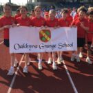 students holding a sign for Oakhyrst Grange school